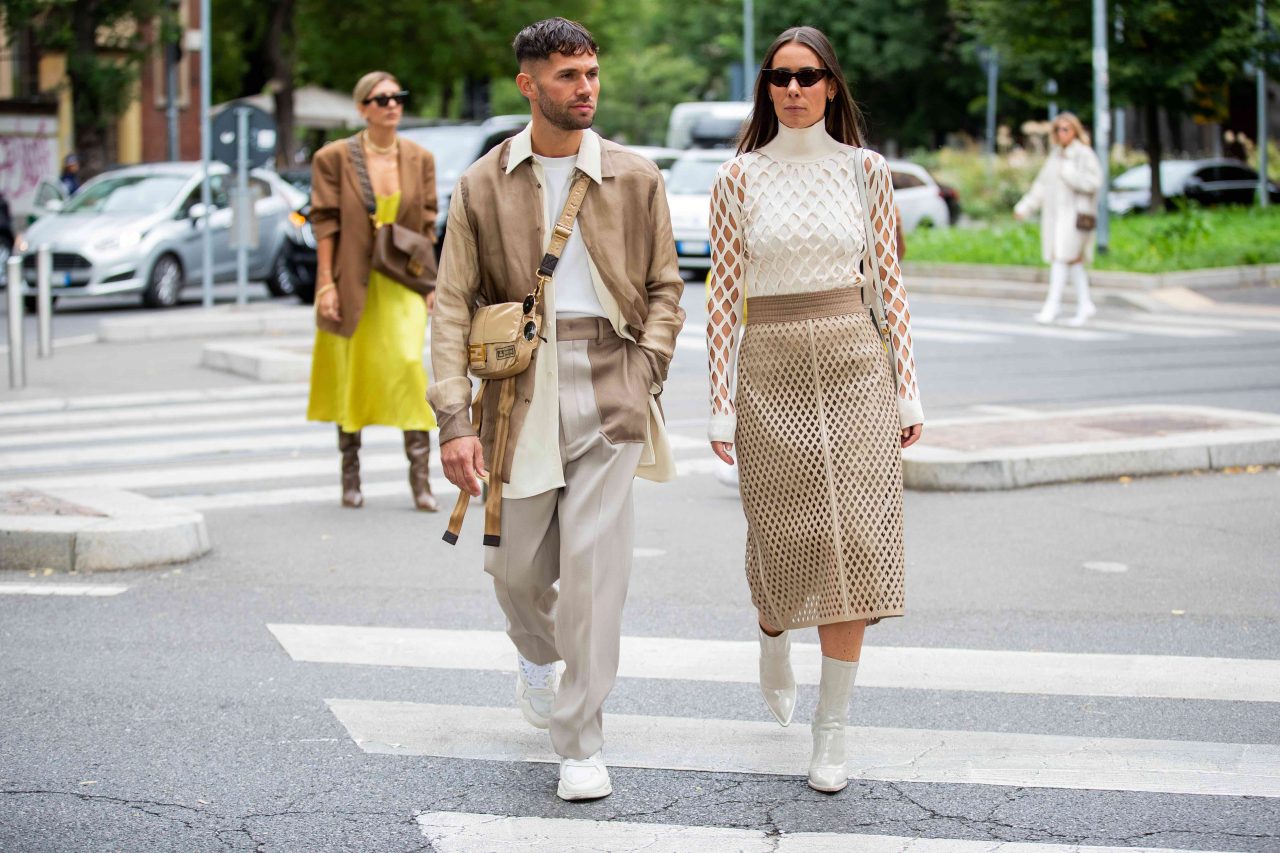 MILAN, ITALY - SEPTEMBER 19: Couple Jean-Sebastien Roques wearing beige jacket, bag, grey two tone pants and Alice Barbier wearing laced white top and beige midi skirt, ankle boots seen outside the Fendi show during Milan Fashion Week Spring/Summer 2020 on September 19, 2019 in Milan, Italy. (Photo by Christian Vierig/Getty Images)