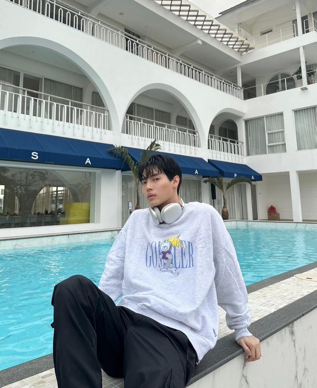 <strong>February 3, 2023</strong> lounging by a pool wearing a sweatshirt from Ambler Korea and Prada Re-Nylon pants